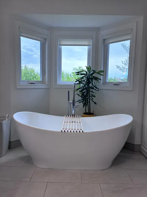 Freestanding tub under a row of windows